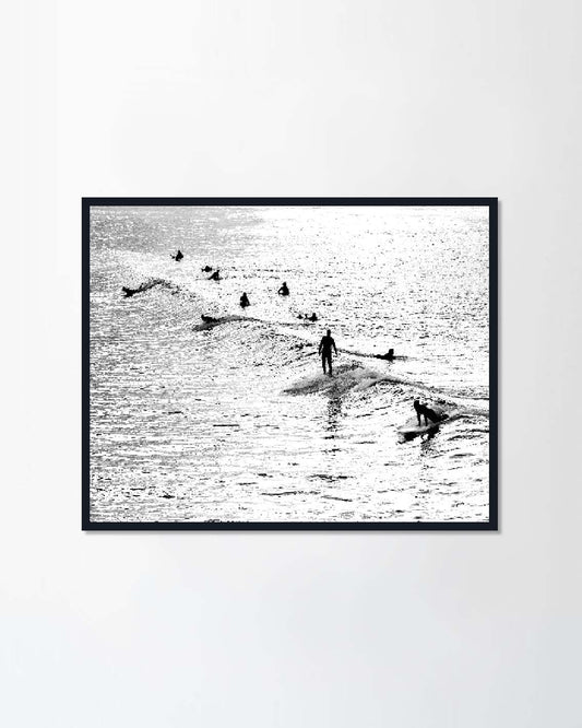 Silhouette of several surfers