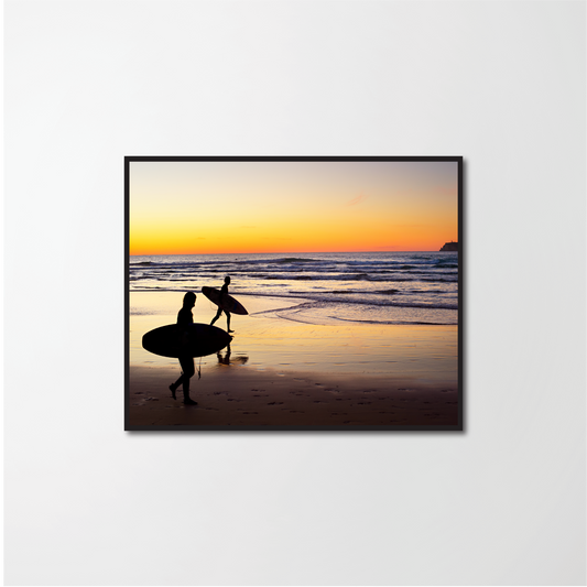 Two surfers running on the beach