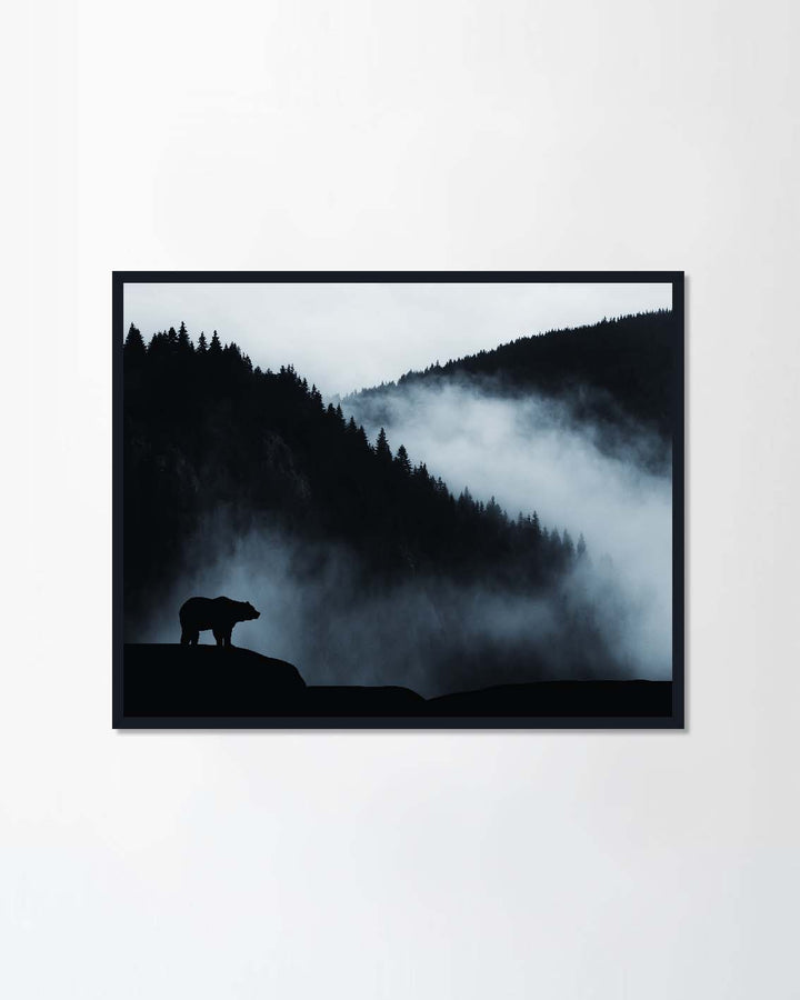 wilderness landscape with bear silhouette and misty mountains
