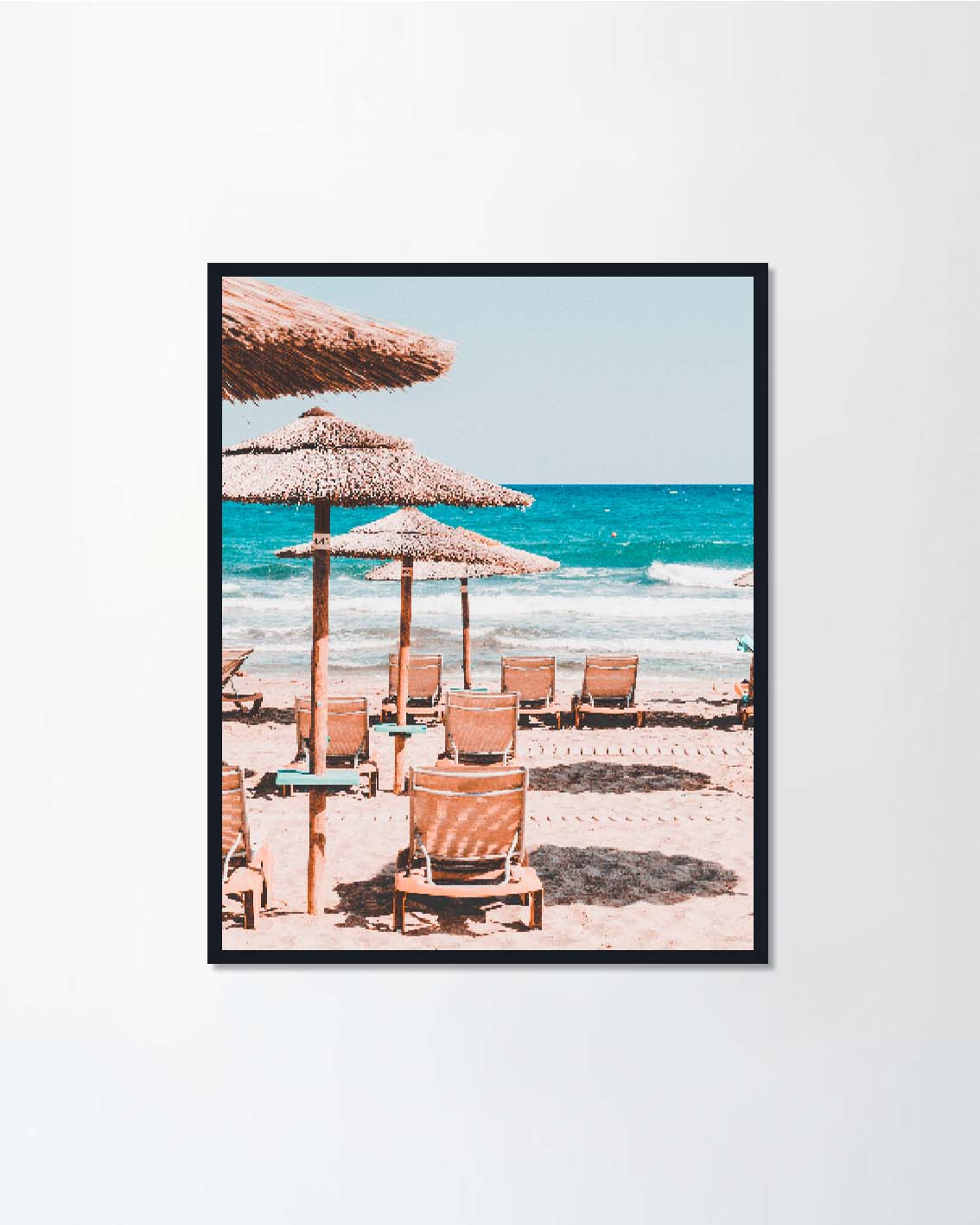 Empty sunbeds and straw umbrellas